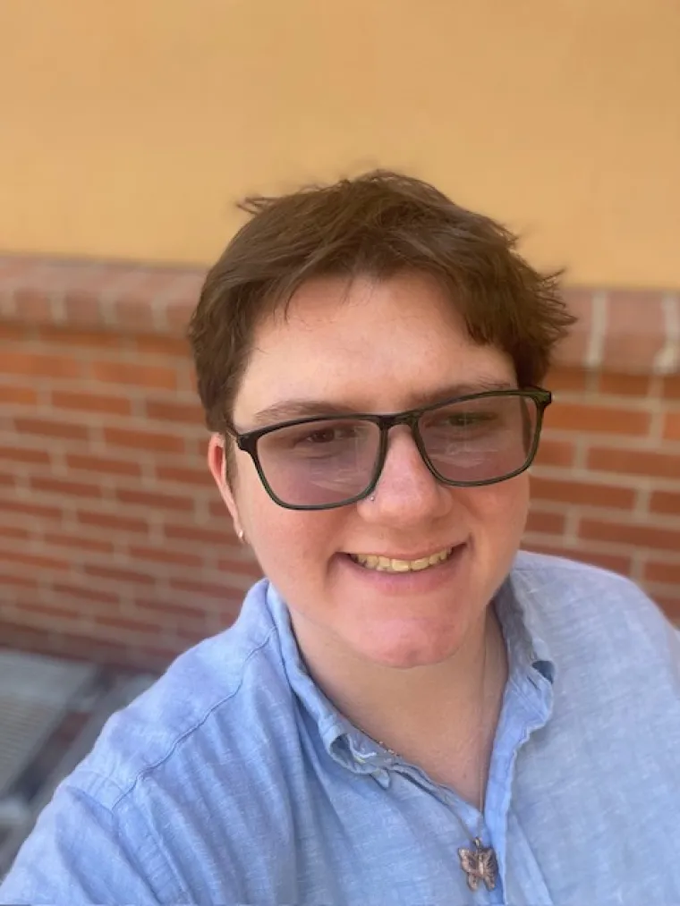 A selfie of Dani wearing a light blue button-up
